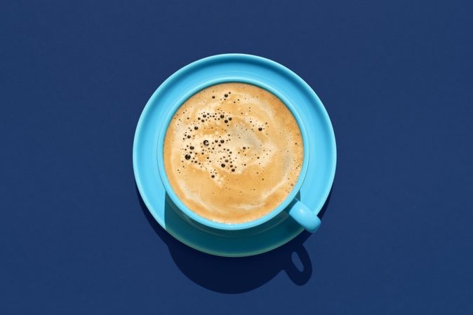 Cup of coffee above view on a blue background