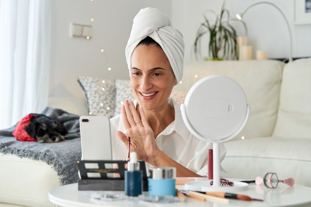 Cheerful beauty blogger greeting followers during online streami
