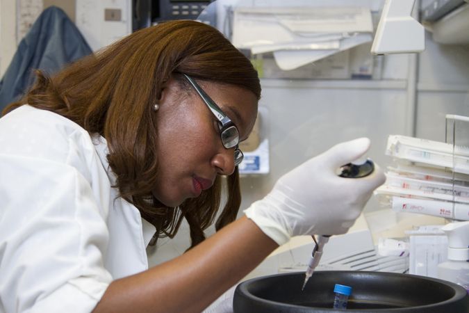 Bethesda, MD - USA,  Sept 2014: A woman scientist pipetting DNA samples