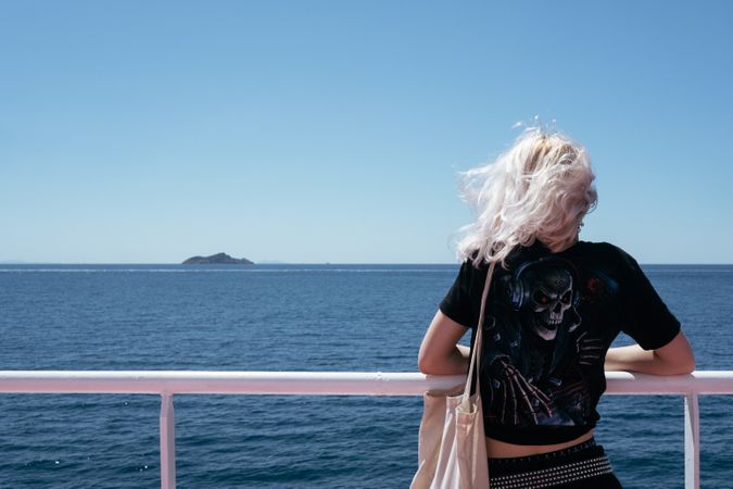 Back of blonde woman on deck of boat