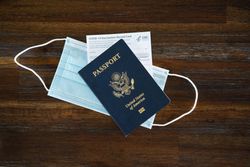 Top view of PPE mask, COVID vaccine card and US passport