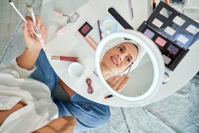 Woman applying eyeshadow with brush in eye makeup