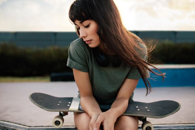 Young female skateboarded relaxing at skate park