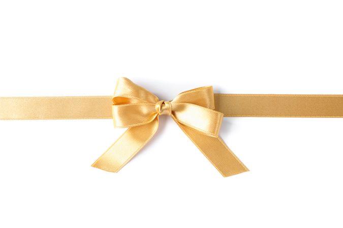Golden ribbon with bow isolated on plain background. Gift concept