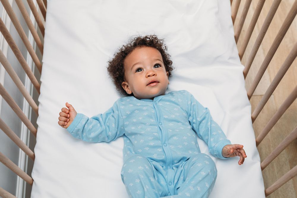 Cute baby boy lying down in his crib