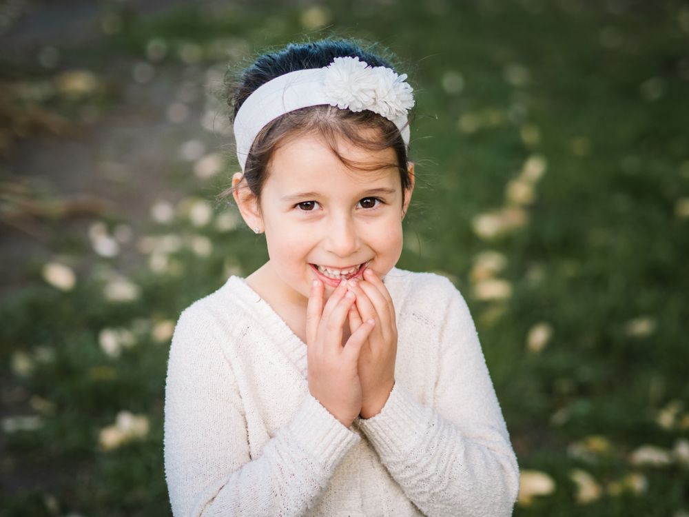 Portrait of charming smiling little girl in park