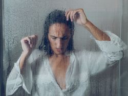 Unpleasant woman near wet glass door