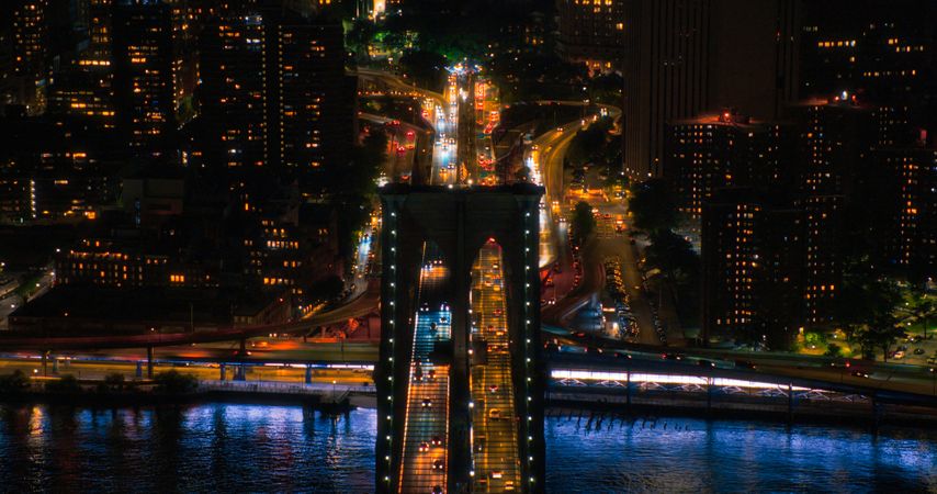Aerial Top Down Night Scenery with Brooklyn Bridge with Car Traffic Moving in Both Directions on the Road. Helicopter Bird's-Eye View of a Popular American Travel and Business Destination
