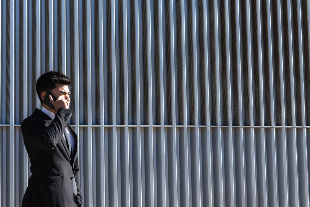 Smiling businessman speaking on smartphone in downtown