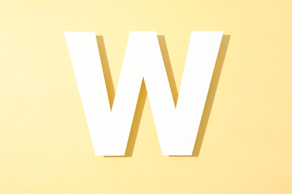 Paper letter W on color background, space for text