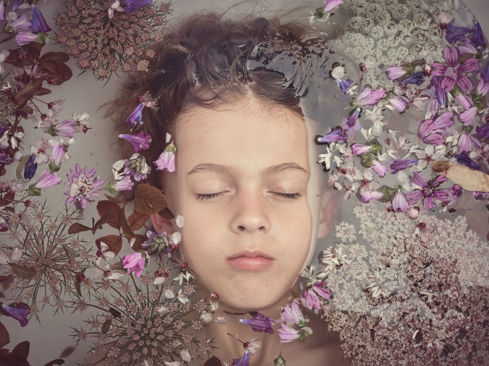 Boy in bath with colorful flowers