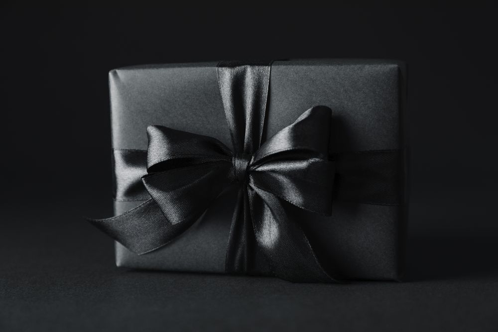 Gift box with dark bow on dark background