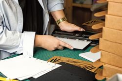 Female hands use hole punch to create perforations in removable paper blocks