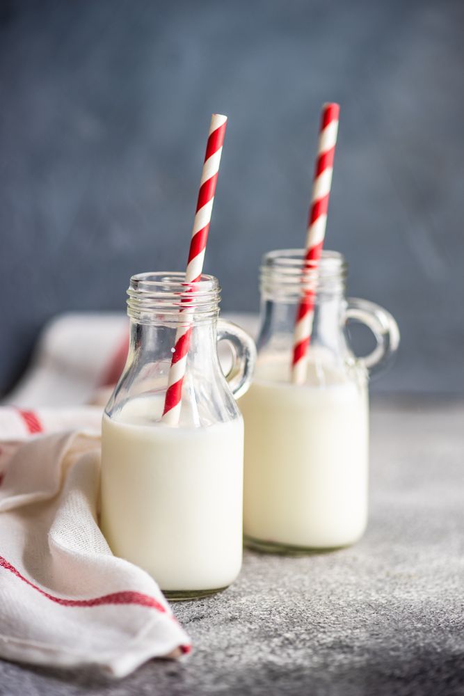 Side view of two bottles of milk on kitchen counter