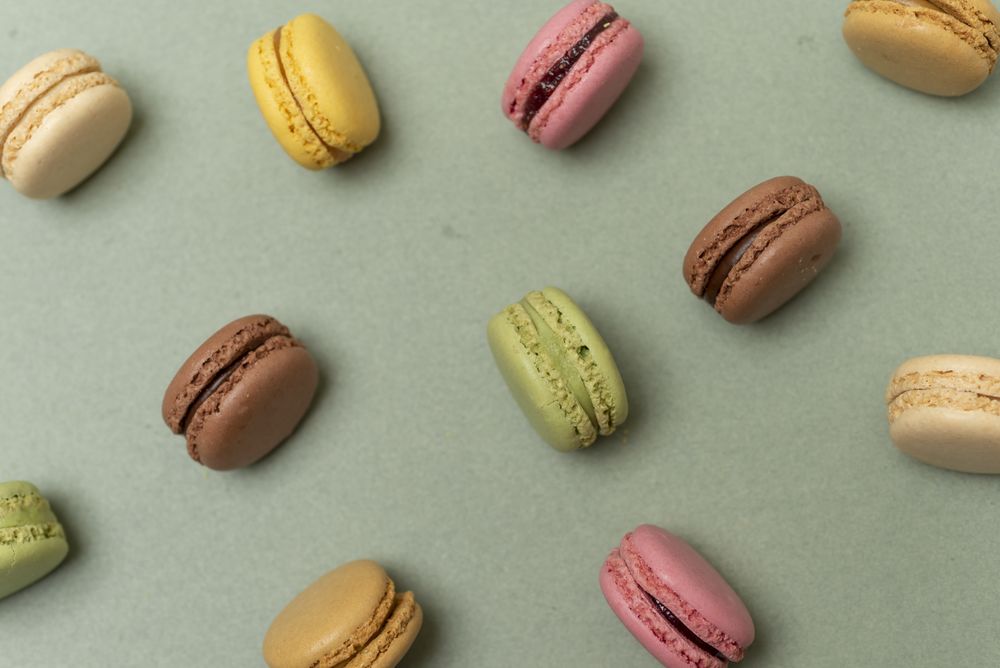 Colored tasty macaroons over a green background
