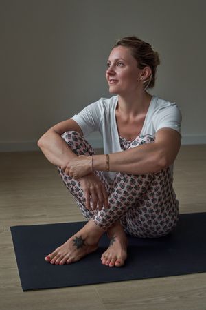 Thoughtful woman resting after yoga lesson in gym