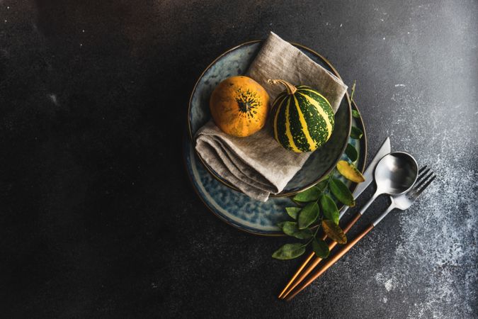 Top view of elegant cutlery with fresh squash on blue tableware