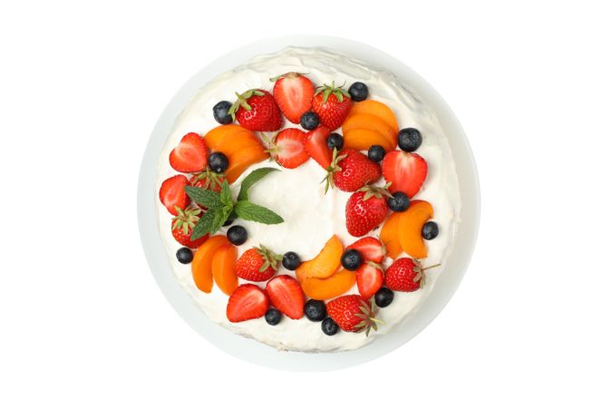 Plate with berry cream cake isolated on plain background