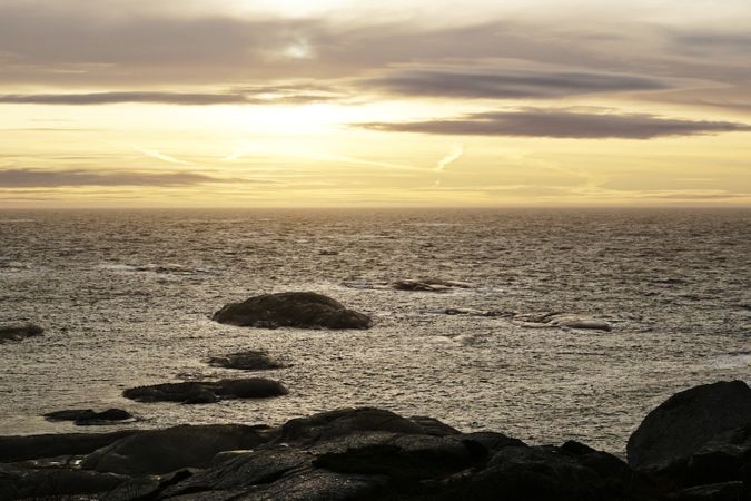Rocky seashore and dark wavy sea in dusk