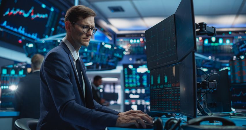 Portrait of Stock Exchange Broker Working on Computer, Researching Real-Time Stocks Data, Analyzing Commodities and Exchange Market Charts.