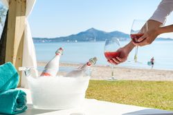 Person serving champagne on beach