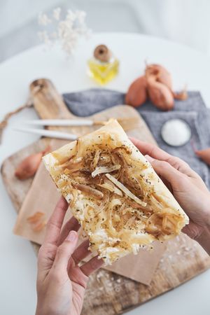 Unrecognizable person with slice of onion tart