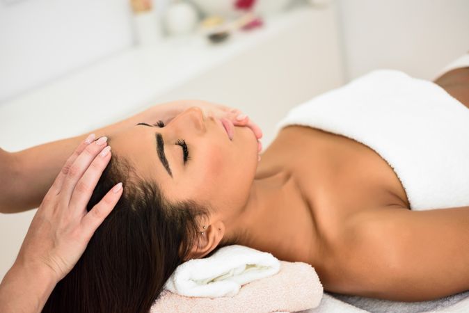 Female having relaxing forehead massage in spa wellness center