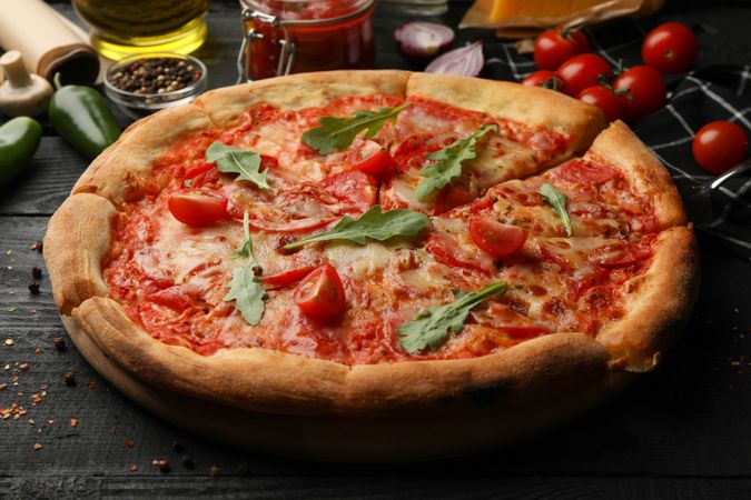 Tasty pizza and ingredients on wooden background