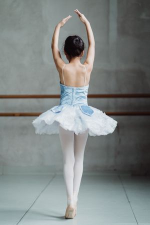 Back view of dancing ballerina in blue tutu