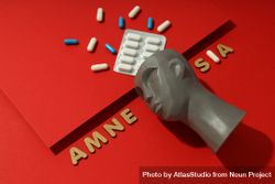 Bust with pills on red background and the words “Amnesia” copy space 4jLQX0