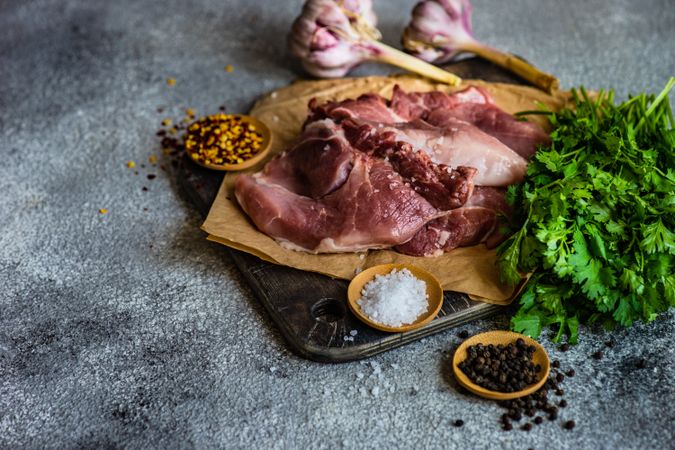 Meat, spices and herbs on cutting board