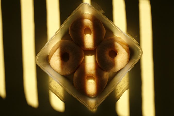 Looking down at box of donuts with dramatic lighting