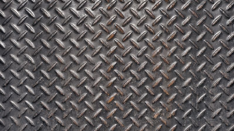 Dark steel floor plate with diamond pattern and industrial texture