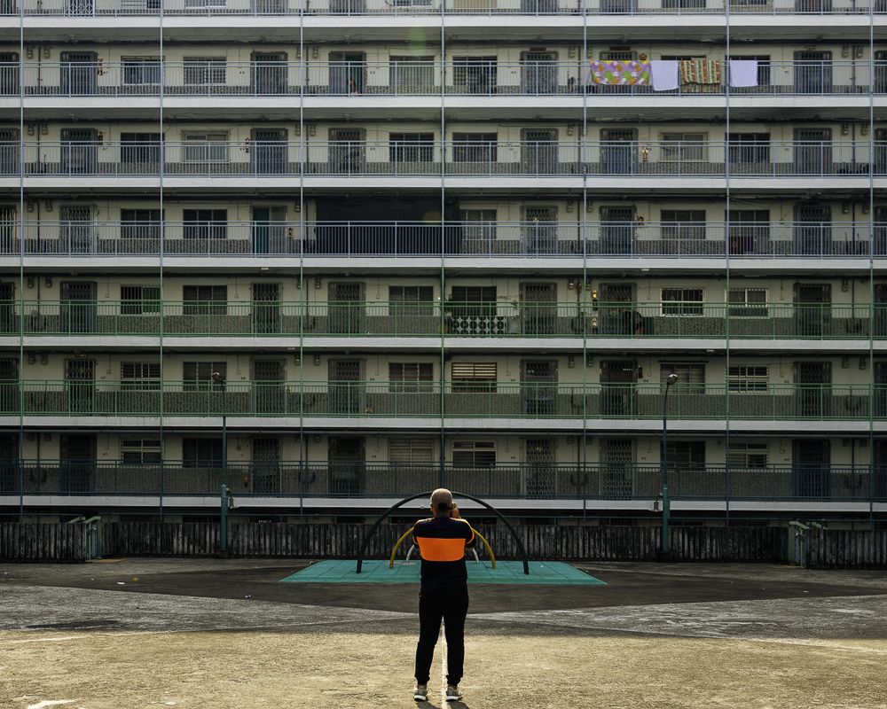 Back view of a man standing in front of a building