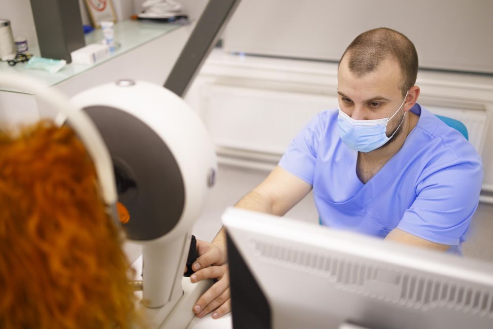 Close up of woman having her eyes checked in machine with male doctor