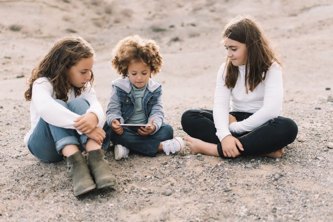 Calm children using smartphone on nature