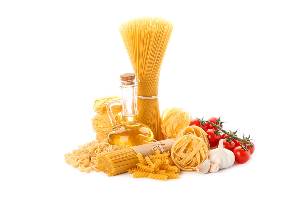 Pasta, olive oil, tomatoes and garlic isolated on light background. Uncooked whole wheat pasta