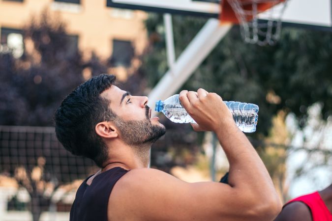 Young man drinking water after doing sports