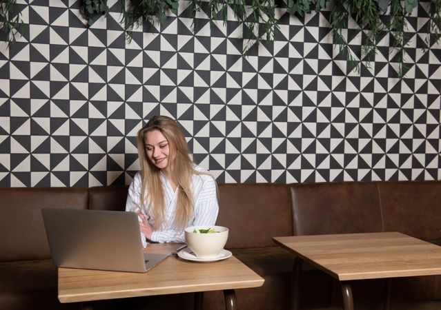 Young woman using laptop in cafe