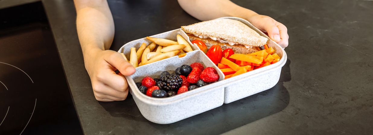 Unrecognizable girl taking lunch box filled with healthy food
