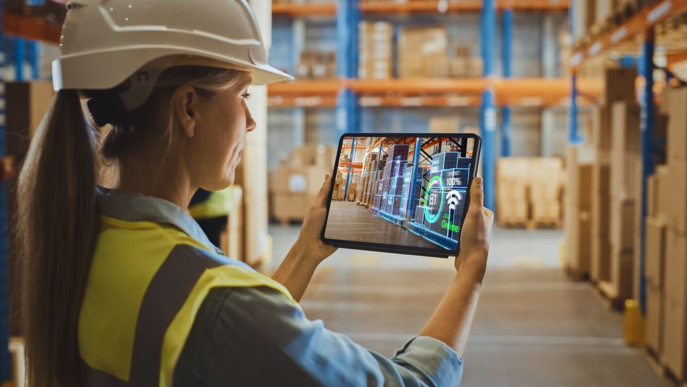 Futuristic Technology Warehouse Concept: Female Worker Doing Inventory, Using Augmented Reality Application On Tablet.