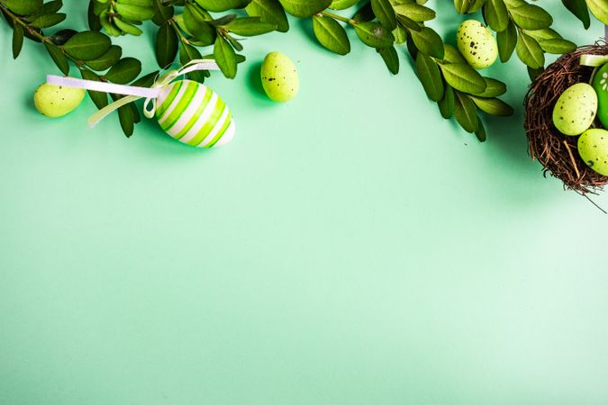 Card concept with pastel green Easter eggs on green background