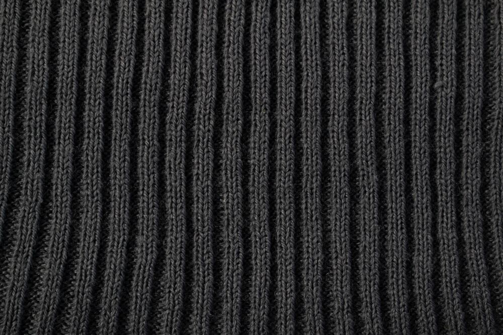 Close up dark grey knitted fabric background texture.
