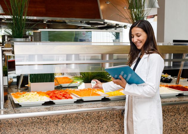 Adult employee checking food quality in canteen