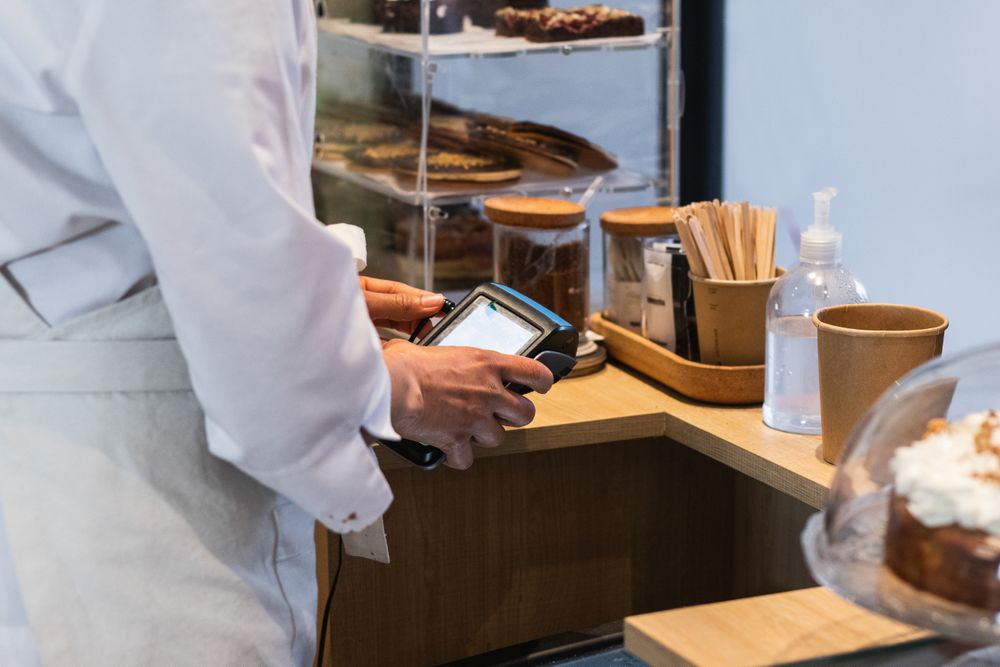 Crop seller using payment terminal in bakery