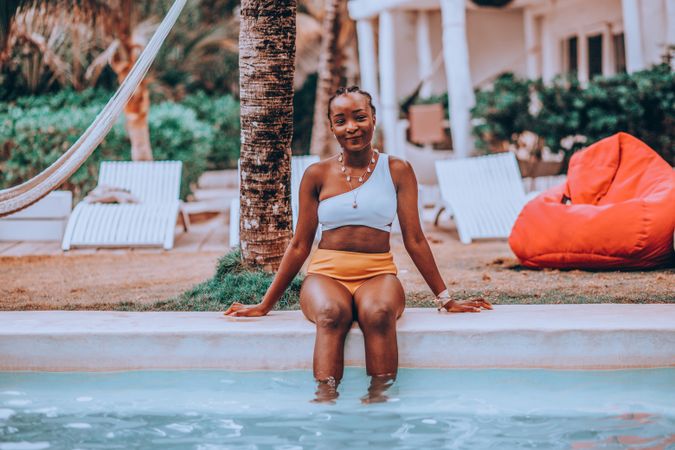 Woman in bathing suit sitting on the edge of the pool