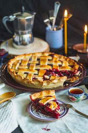 Baked pie with cherry filling on table with tea cup