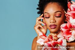 Studio shoot of Black woman surrounded by flowers with copy space 5Xmyk4