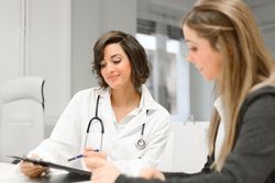 Female doctor with female patient in clinic