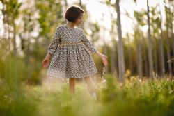 Girl standing in dress in nature surrounded by trees